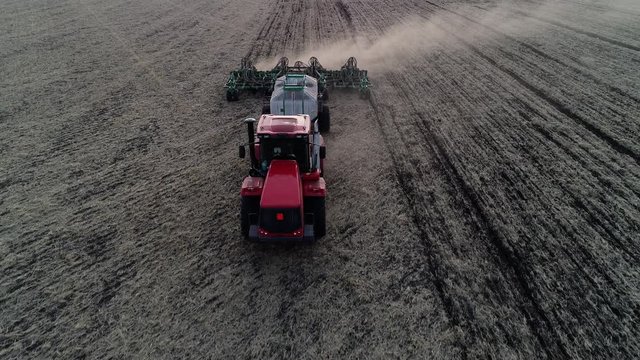Aerial view of farming work, plowing and sowing by tractor or agriculture machine on rural farm, farmland field. Industry on spring land, planting seed on countryside landscape by industrial equipment