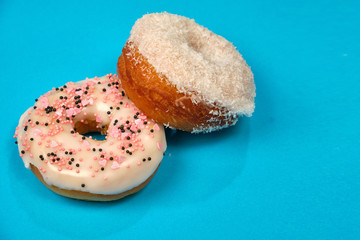 doughnuts with icing and topping on a blue background, space for text
