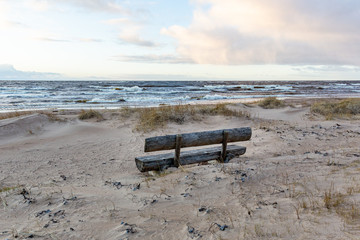 Bench for relaxation at the beach on a windy day in January at the Baltic sea in Skulte in Latvia