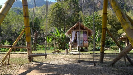 Fototapeta na wymiar wooden swing In a natural atmosphere that overlooks trees and mountains.