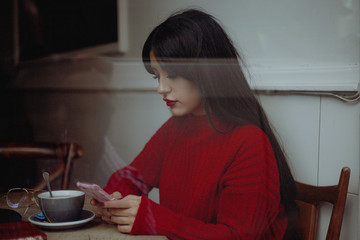 portrait of young hispter woman in Red sweater looking phone