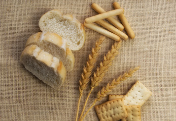 Bakery. Dry bread, slices of bread, bread sticks and wheat branches, on a linen napkin. Close up and depth of field
