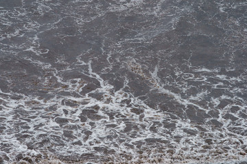 Photography of oceanic shore. Soft surf, waves and water surface. Natural background. Concepts of beauty in nature and tourism and touristic time.