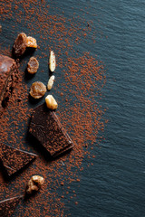 Aerial view of chocolate, nuts and cocoa on slate plate