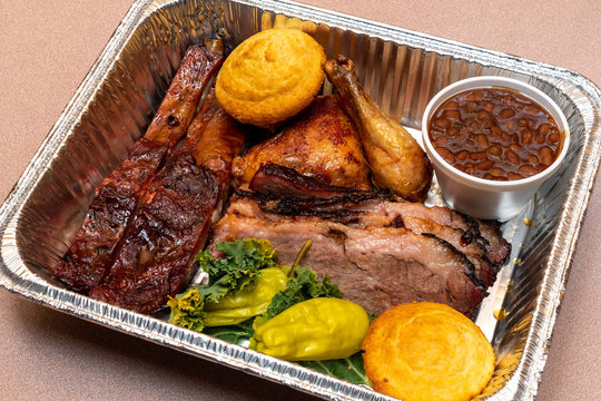 Barbecue Meat Combination Meal In A Foil Pan With Ribs, Brisket, Chicken And BBQ Baked Beans