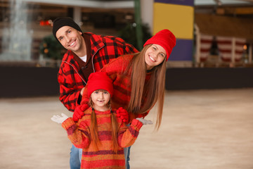 Happy family on skating rink