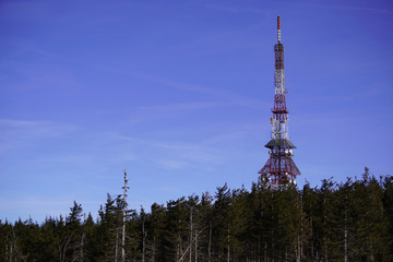 transmitter and repeater signal in the woods against the blue sky and clouds. Telecommunication...