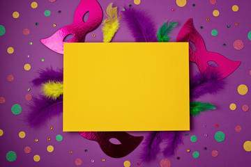 Festive, colorful mardi gras or carnivale mask and accessories over purple background. Party...