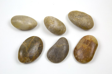 Fototapeta na wymiar Marine semi-circular polished stones grey brown and yellow colors isolated on white background.