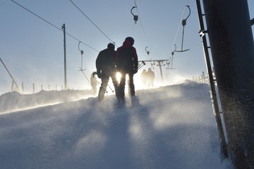 Silhouettes of persons in ski lift a windy afternoon, Sweden, Sälen, 2019