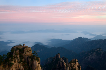 Obraz premium Sunrise red sky at Monkey watching the Sea Peak with fog in valley at Huangshan Mountains China