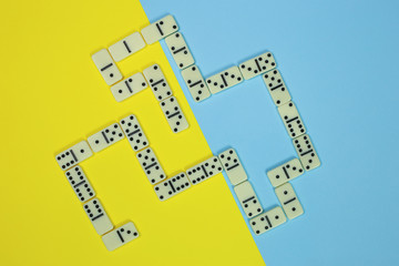 Playing domino on a bright bicolor background, top view