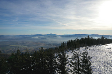 Panorama Beskid slaski . Mountain view from Skrzyczne peak in Szczyrk, Silesian region, Poland on a foggy and Sunny winter day. The mountains are partially covered with snow.