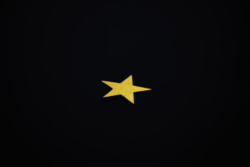 golden star on a black background. Macro shot.