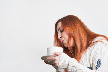 A woman with freckles drinking coffee