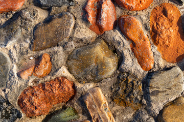Background of colored stones. The surface is decorated with natural material. Pattern on the floor of multicolored pebbles.