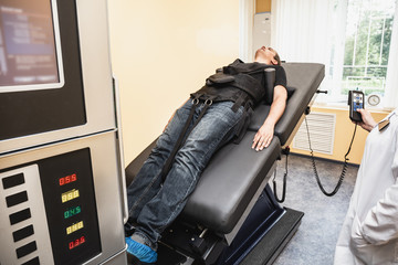 Man with problems of low back spinal hernia on stretching and decompression procedure in medical...