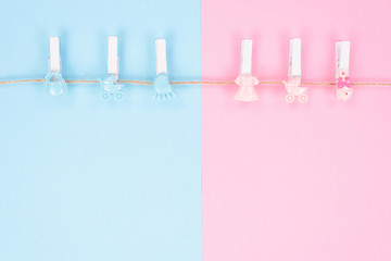 Gender reveal party invitation concept. Background photography of small pegs with carriage toys...