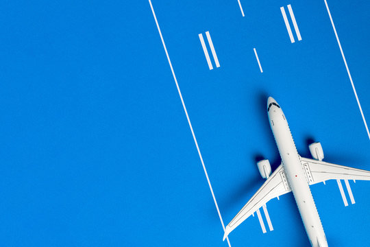 Aircraft Model On Blue Runway, Top View With Empty Space For Text. Concept Of Aircraft Industry, Airline Safety, Security And Traveling Insurance