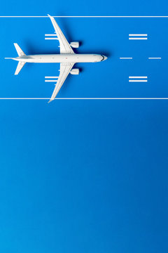 Model plane, airplane on runway on blue background. Flat lay design, top view. With copy space, mockup or template