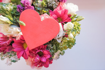 Valentine's day elegant bouquet with roses flowers, Lisianthus, chrysanthemum and red wooden heart, sign of love. Happy Valentines Day. Anniversary concept.happy mother's day.