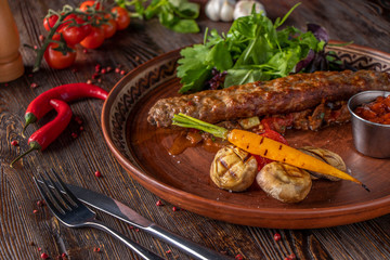 Turkish and Arabic Traditional Ramadan mix kebab plate, Kebab beef with baked vegetables, mushrooms and tomato sauce on wooden background, Horizontal photo