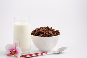 Breakfast cereal, cornflake chocolate in cups and milk is a healthy breakfast that is healthy for the body every day on a white background.
