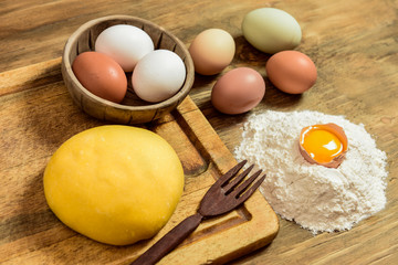 Egg noodle dough bun, with ingredients on the table.