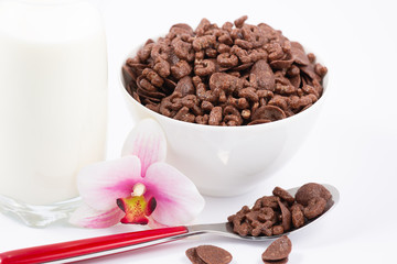 Breakfast cereal, cornflake chocolate in cups and milk is a healthy breakfast that is healthy for the body every day on a white background.