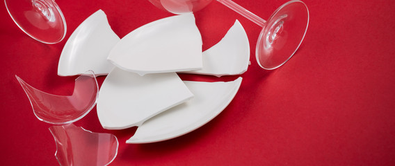 Broken Plate or broken water glass on the on the red background The concept of accidents in the...