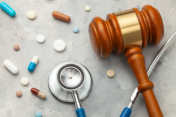 Judge gavel and stethoscope with pills. The law in medicine, the sentence on medical negligence.