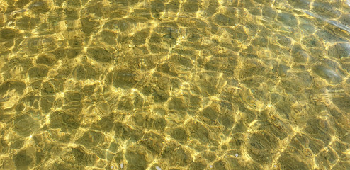 Fototapeta na wymiar Beautiful clear water with light ripples of a summer lake