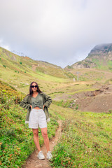 Naklejka premium Beautiful happy young woman in mountains in the background of fog