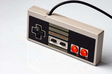 Retro gaming controller with cable on white background