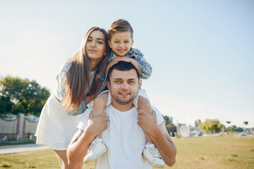 Family in a summer park. Father in a white shirt. Cute little son