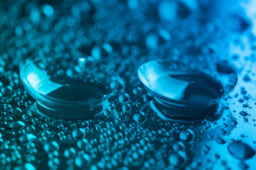 Contact lenses, on green-blue background.