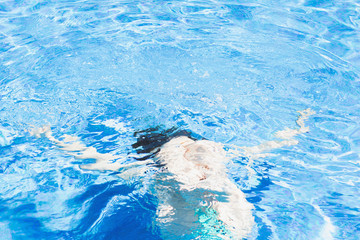 Woman silhouette  in the pool water. Tropical vacation theme concept.