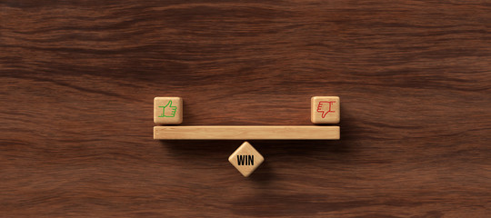 wooden blocks formed as a seesaw with thumbs up and down icons on wooden background