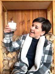 Beautiful girl with a French bulldog and a glass of milk on wood background