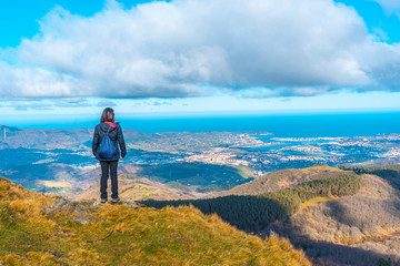 Naklejka premium A young mountaineer looking at the village of Fuenterrabia from the mountain of Aiako Harria, Oiartzun. Basque Country
