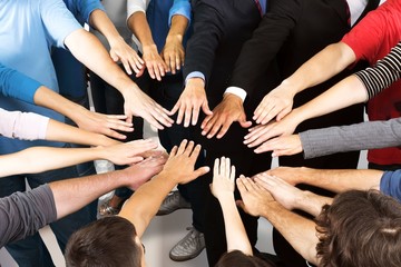 Hands of many young business people in the circle