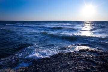 Beautiful blue sunset and water stones over Black sea rocky coastline in Crimea on summer day. Natural landscape background and wallpaper