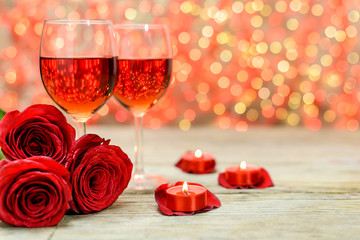 A glasses of wine, roses and burning candles
