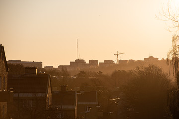 Early morning silhouette of apartment buildings, a crane and a telecommunications mast.