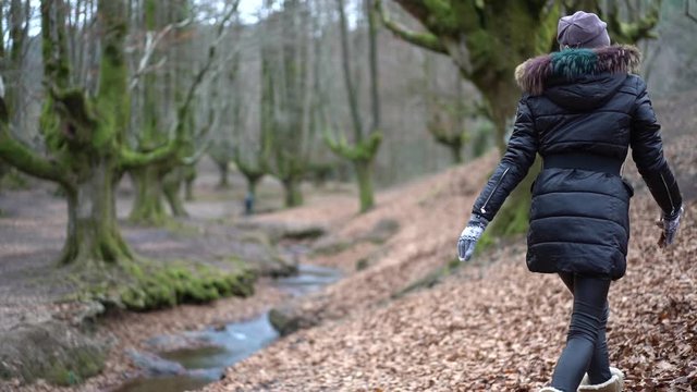A young girl playing with the leaves in autumn in a forest called Otzarreta in the natural park of Gorbea. Basque Country