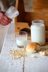 Still life with milk and bread on a white wooden background