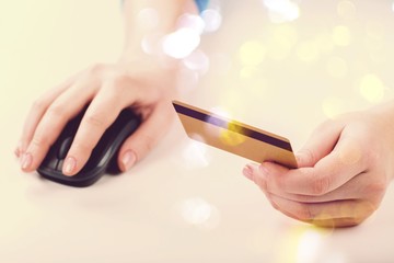 Credit card and a computer mouse in human hands
