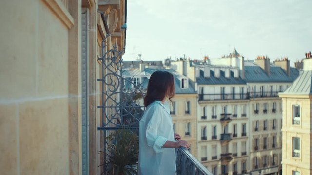 Beautiful woman on the balcony in Paris in the morning