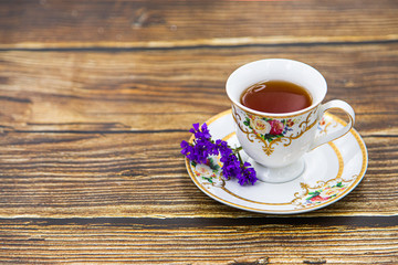Cup of tea with macaroons on pink background