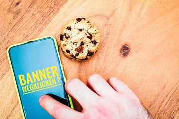 Cookies mit einem Tablet zur Verdeutlichung von Cookie Bannern für Websites mit auf deutsch Banner wegklicken in English Click away the banner
